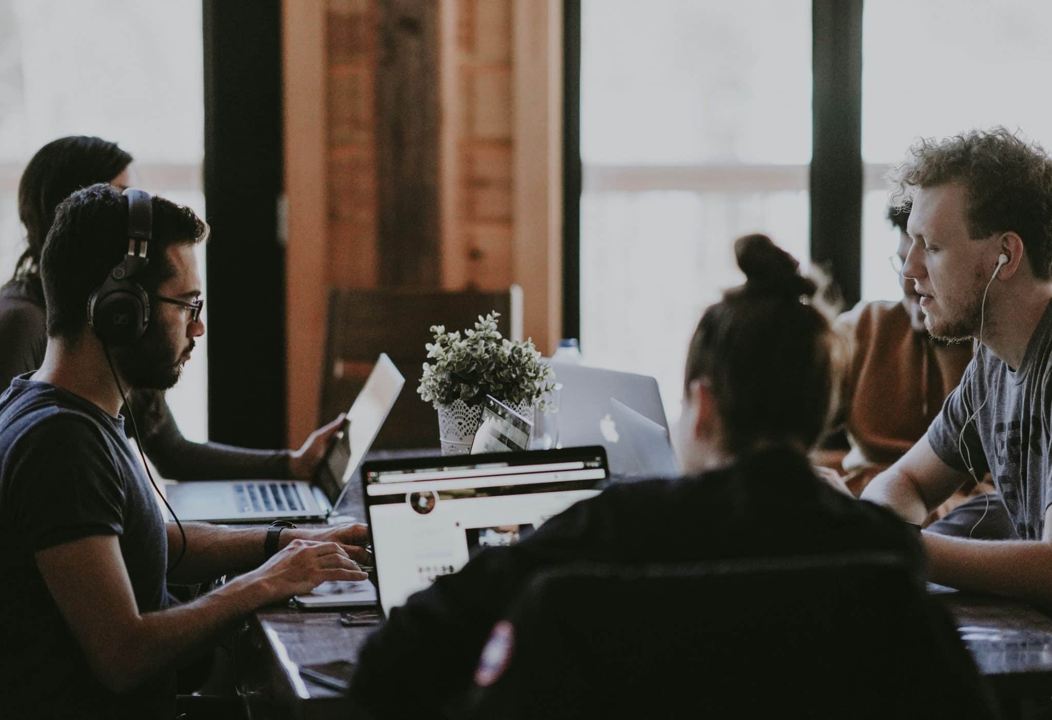 The picture captures a couple of people sitting around a desk, deeply engrossed in discussion. Their collaboration signifies productivity at work. The intensity of their conversation suggests problem-solving or brainstorming, key components of efficient teamwork. This image exemplifies how communication and collaboration foster productivity in a professional setting