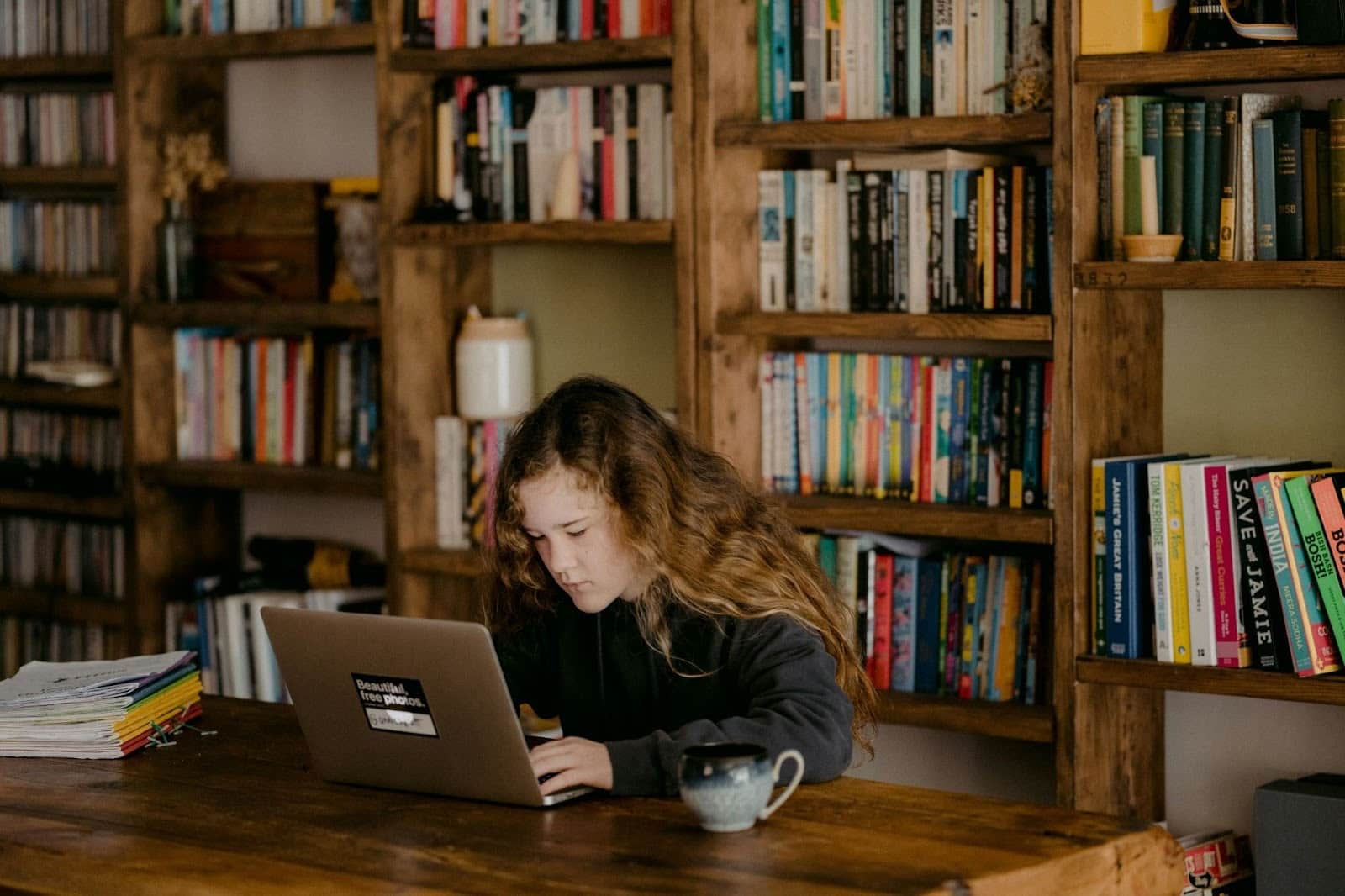 Young woman working on her MacBook in a calm space and studying without distractions