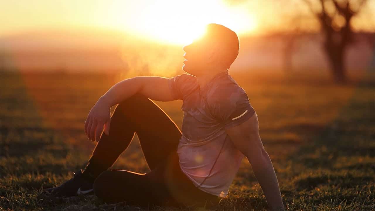 dopamine reset moment with person sitting in sunlight outdoors, reducing digital stimulation to restore focus and mental clarity