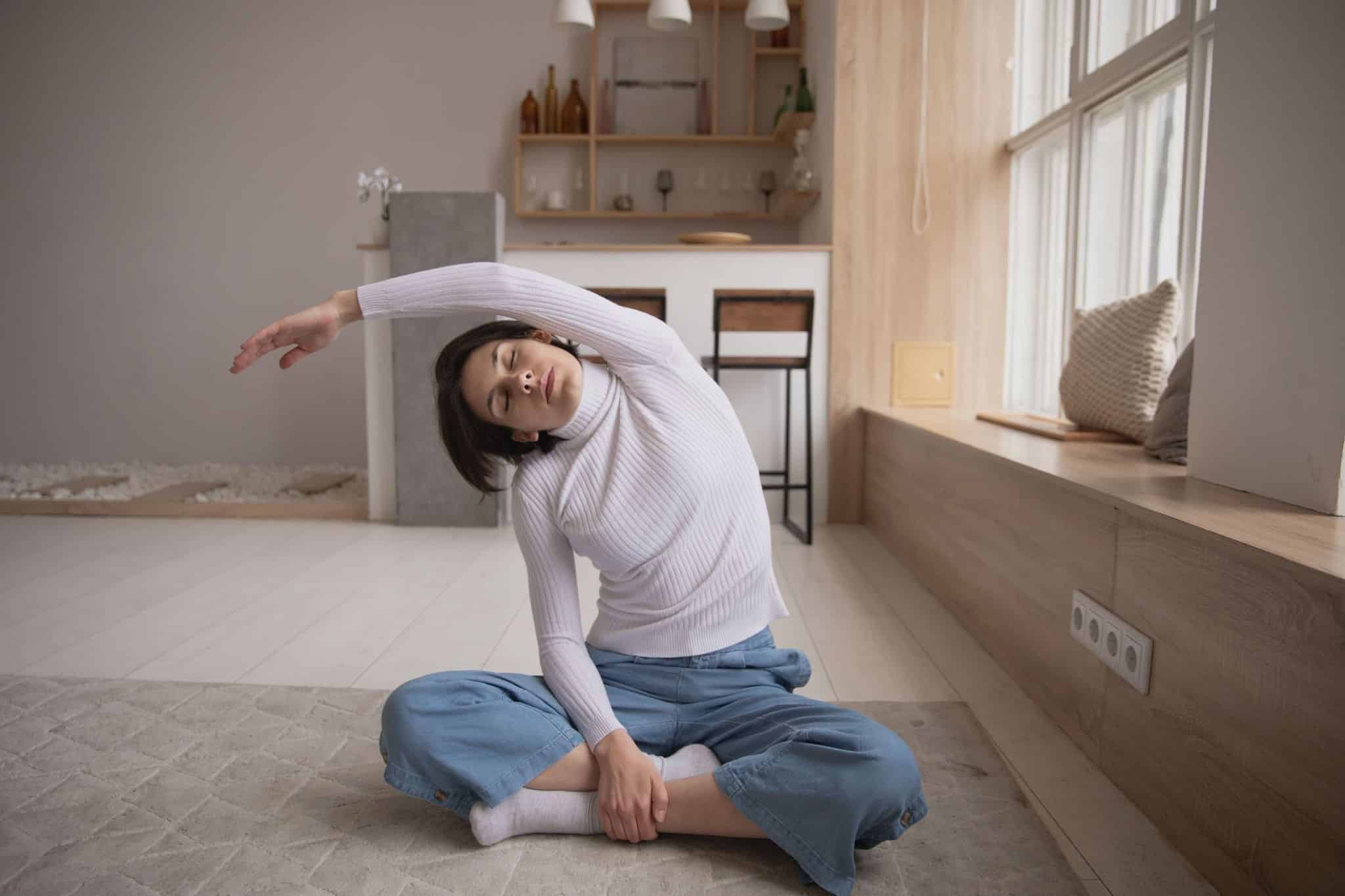Woman stretching while sitting cross-legged.